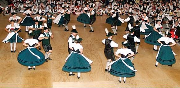 Men in black color dress and women in green color dress are dancing together